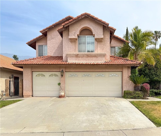 view of front facade with concrete driveway, a tiled roof, an attached garage, and stucco siding