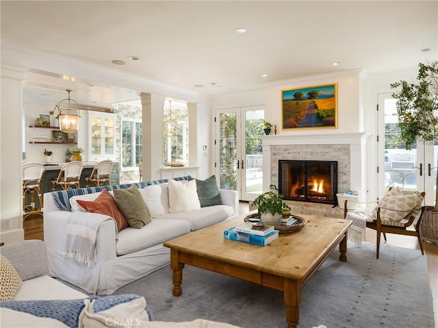 living area featuring ornamental molding, a fireplace, recessed lighting, and wood finished floors