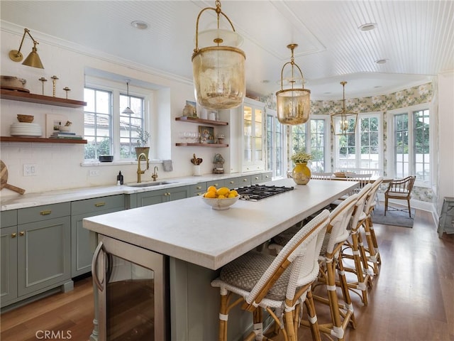 kitchen with open shelves, a sink, plenty of natural light, wood finished floors, and wine cooler