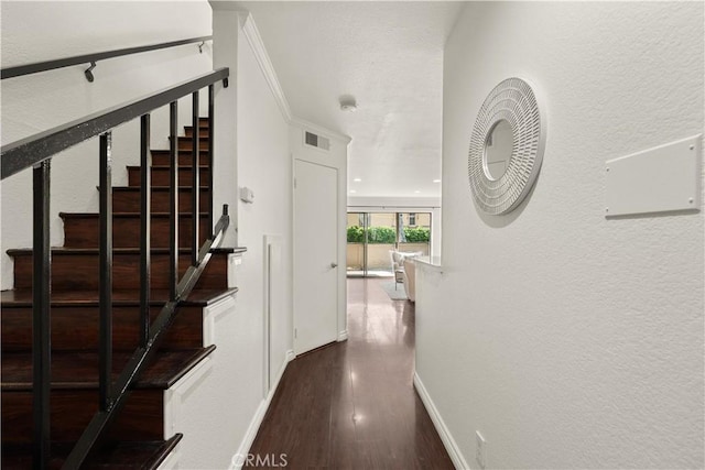 hallway with baseboards, visible vents, dark wood finished floors, and stairway