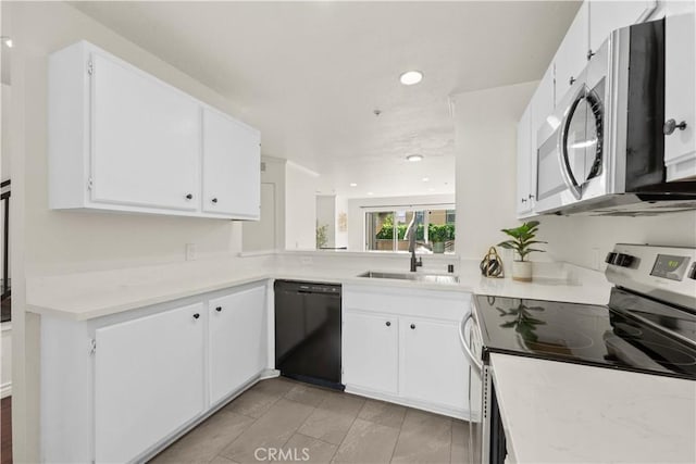 kitchen featuring white cabinets, appliances with stainless steel finishes, a sink, light countertops, and recessed lighting