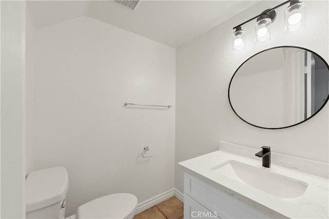 half bath with toilet, tile patterned floors, visible vents, and vanity