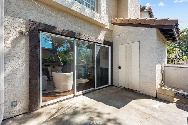doorway to property featuring stucco siding and a patio area