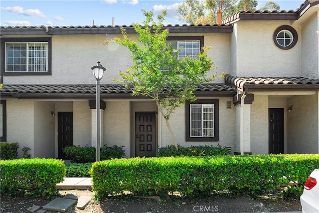 view of front of property with stucco siding and a tile roof