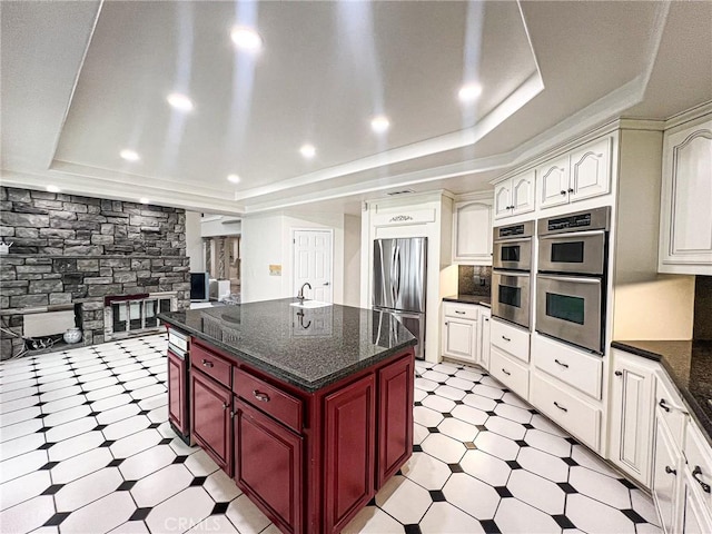6926 Orozco Dr, Riverside, CA 92506 - kitchen featuring dark brown cabinets, light floors, a center island, a raised ceiling, and appliances with stainless steel finishes