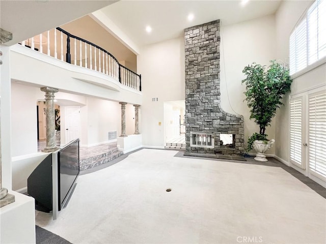 6926 Orozco Dr, Riverside, CA 92506 - unfurnished living room with carpet flooring, a high ceiling, a fireplace, baseboards, and ornate columns