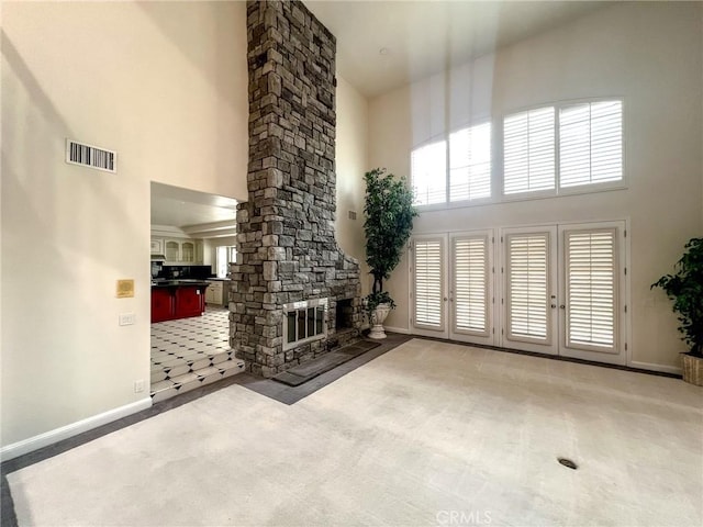 6926 Orozco Dr, Riverside, CA 92506 - carpeted living area featuring visible vents, baseboards, a high ceiling, and a fireplace