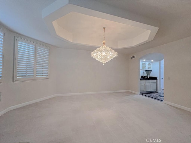 6926 Orozco Dr, Riverside, CA 92506 - empty room with an inviting chandelier, a raised ceiling, arched walkways, baseboards, and visible vents