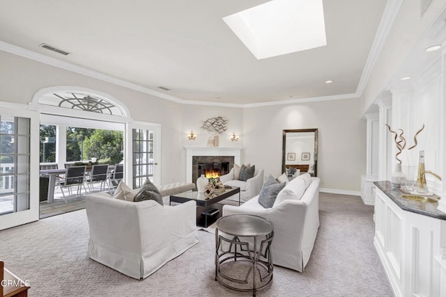 living area with a high end fireplace, ornamental molding, light carpet, and visible vents