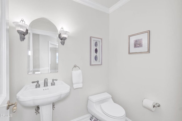 half bathroom featuring baseboards, crown molding, and toilet