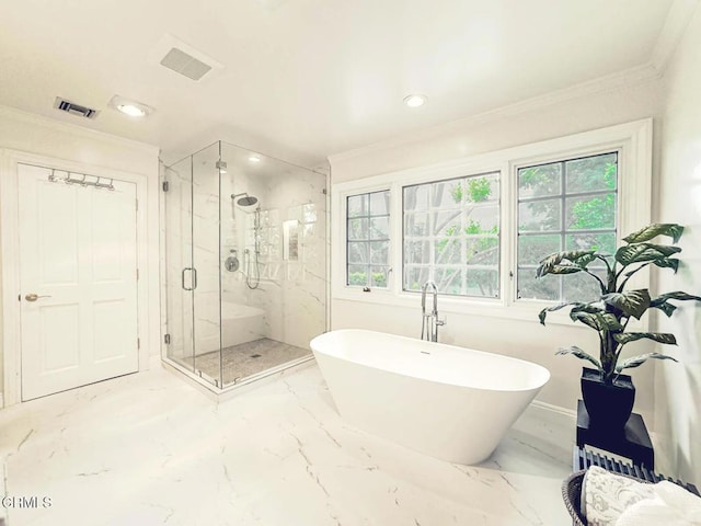 bathroom with crown molding, a freestanding tub, and visible vents
