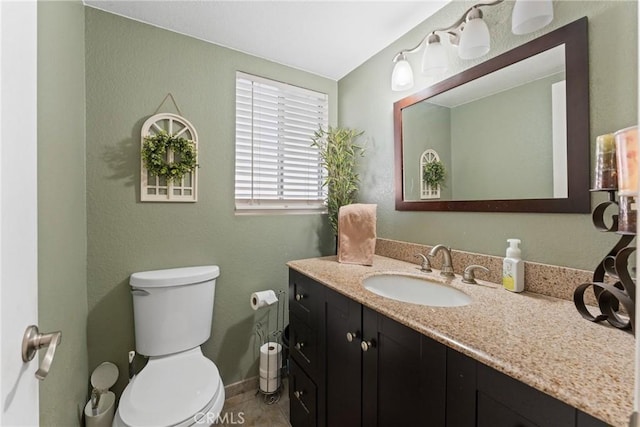bathroom with vanity, baseboards, and toilet