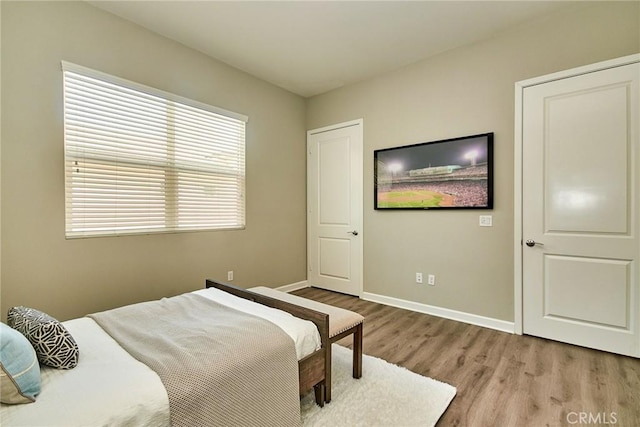 bedroom with baseboards and wood finished floors