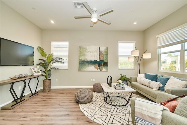 living room featuring plenty of natural light, a ceiling fan, wood finished floors, and visible vents