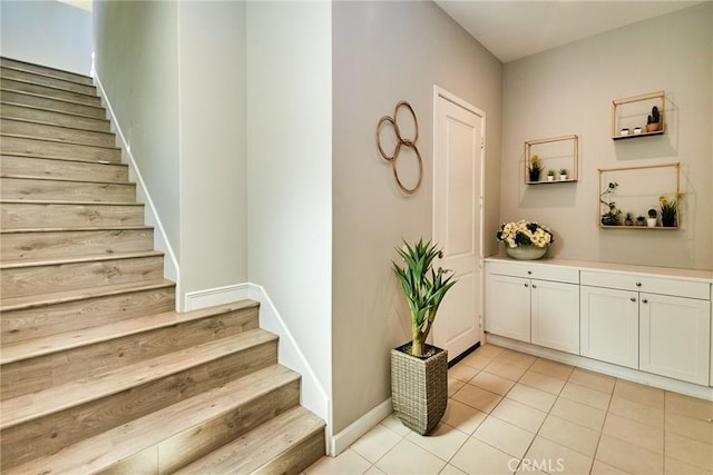 staircase with baseboards and tile patterned flooring