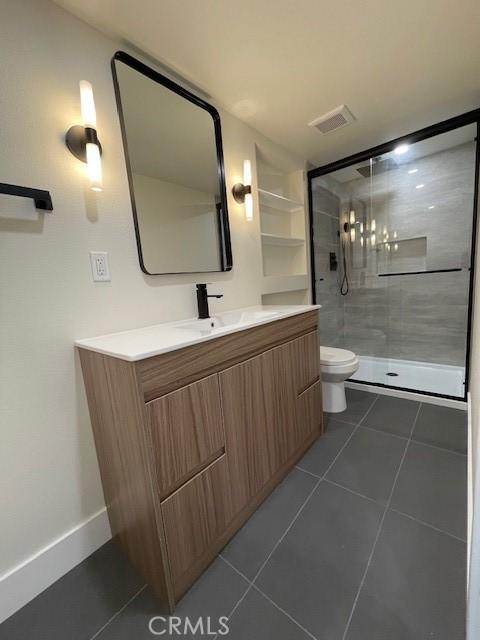 bathroom featuring vanity, toilet, tile patterned floors, a shower stall, and visible vents