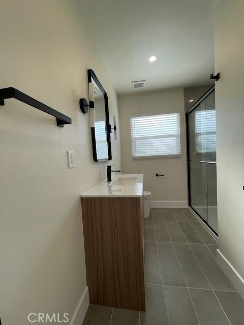 bathroom with baseboards, visible vents, a shower stall, and tile patterned flooring
