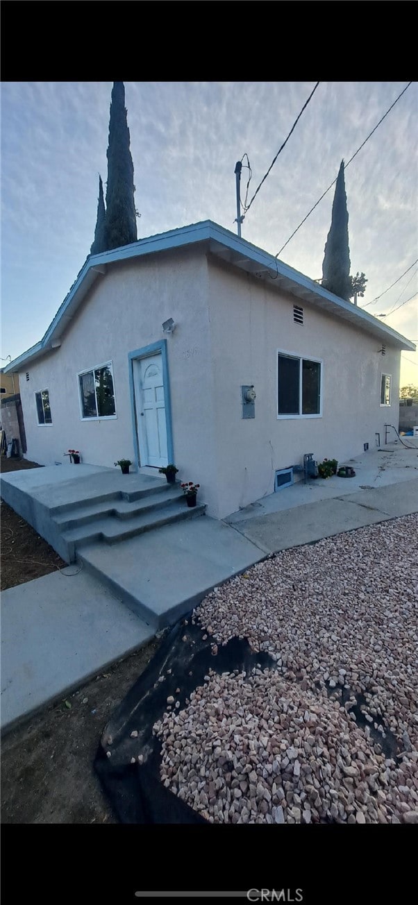rear view of house with stucco siding