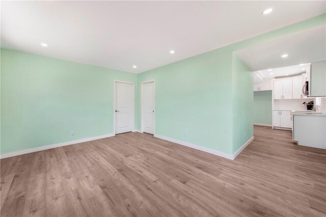 3882 Dwiggins St, Los Angeles, CA 90063 - unfurnished living room featuring light wood-type flooring, baseboards, and recessed lighting