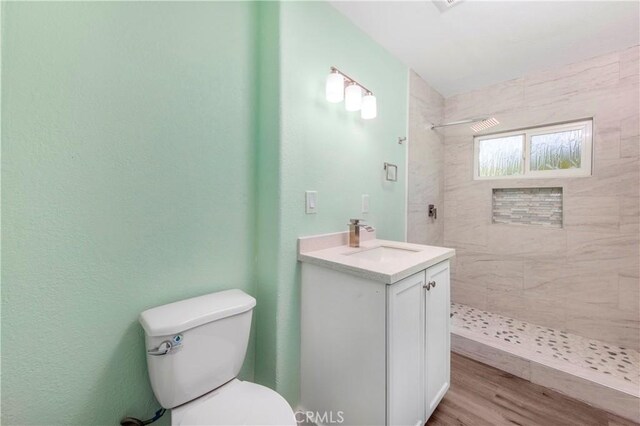 3882 Dwiggins St, Los Angeles, CA 90063 - bathroom with toilet, vanity, tiled shower, and wood finished floors