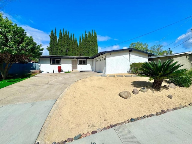 single story home featuring a garage, stucco siding, and driveway