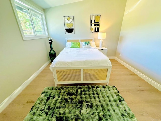 bedroom featuring baseboards and wood finished floors