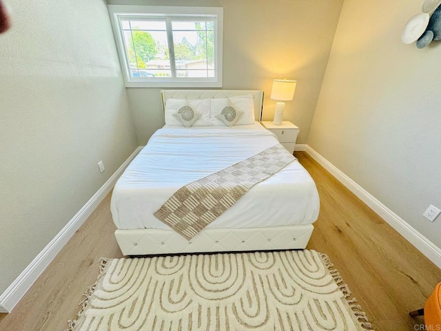 bedroom featuring baseboards and wood finished floors