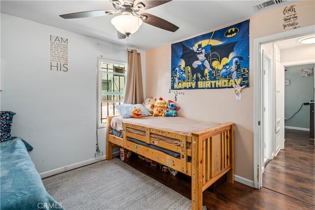 bedroom featuring baseboards, a ceiling fan, wood finished floors, and visible vents