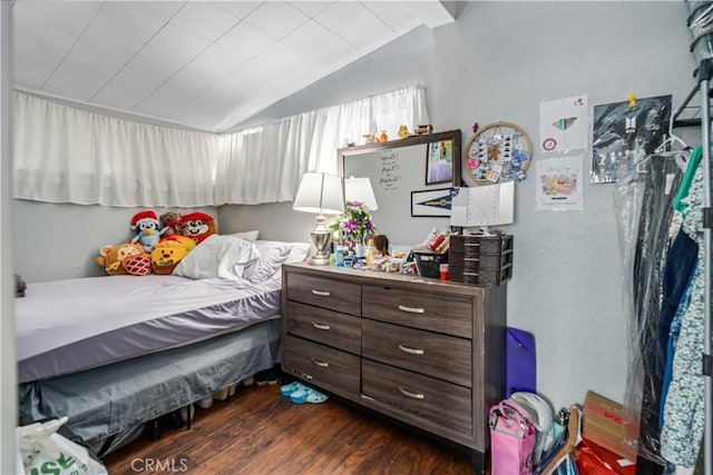 bedroom with dark wood-style floors and lofted ceiling