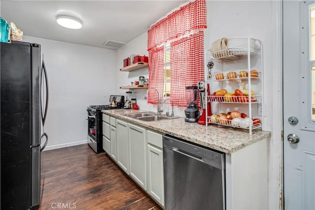 kitchen with open shelves, a sink, baseboards, dark wood-style floors, and stainless steel appliances