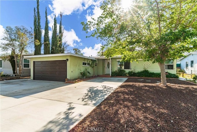 ranch-style house featuring stucco siding, driveway, and a garage