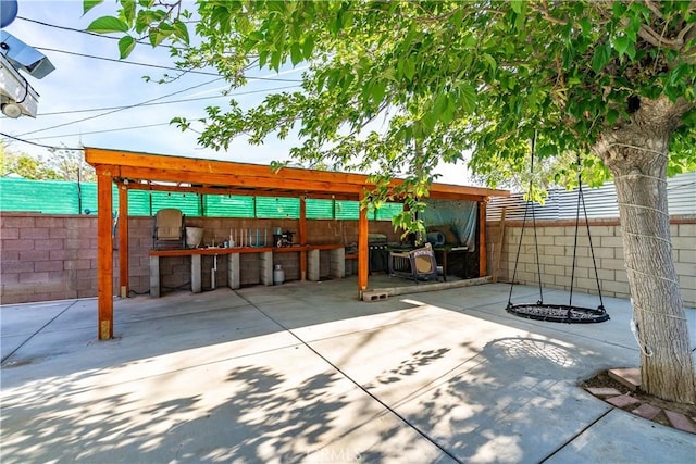 view of patio / terrace with exterior kitchen, a fenced backyard, and outdoor dry bar