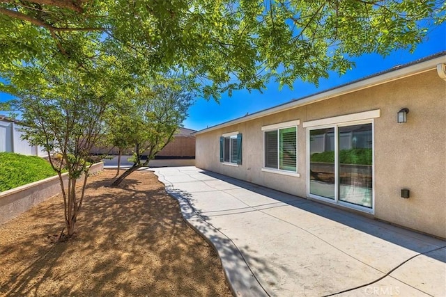 view of property exterior featuring a fenced backyard, a patio area, and stucco siding