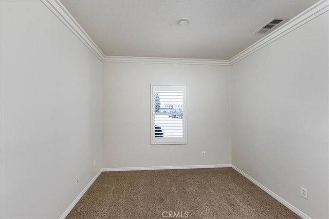 empty room featuring visible vents, ornamental molding, baseboards, and carpet floors