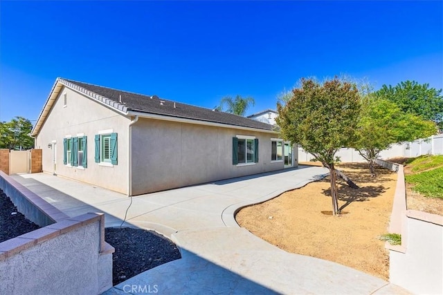 back of house featuring a fenced backyard, a patio area, and stucco siding