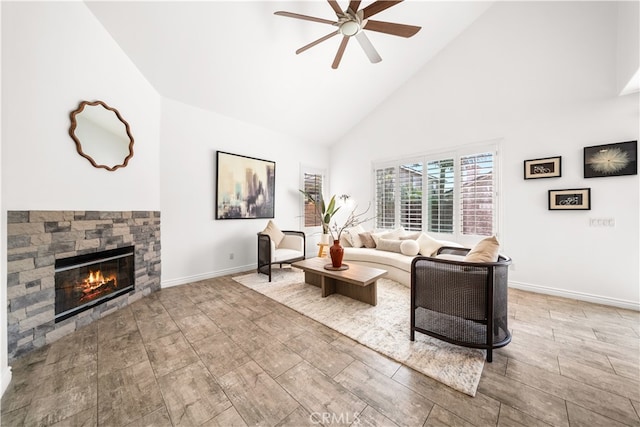 living area with wood finished floors, a fireplace, baseboards, high vaulted ceiling, and a ceiling fan