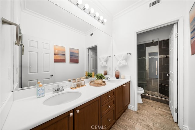 full bath featuring visible vents, a shower stall, a sink, toilet, and ornamental molding