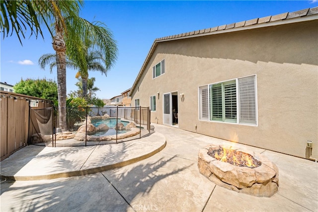 exterior space featuring an outdoor fire pit, stucco siding, a fenced backyard, a fenced in pool, and a patio