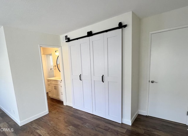 333 Highland Dr, Oxnard, CA 93035 - unfurnished bedroom featuring dark wood-style floors, a barn door, and a closet