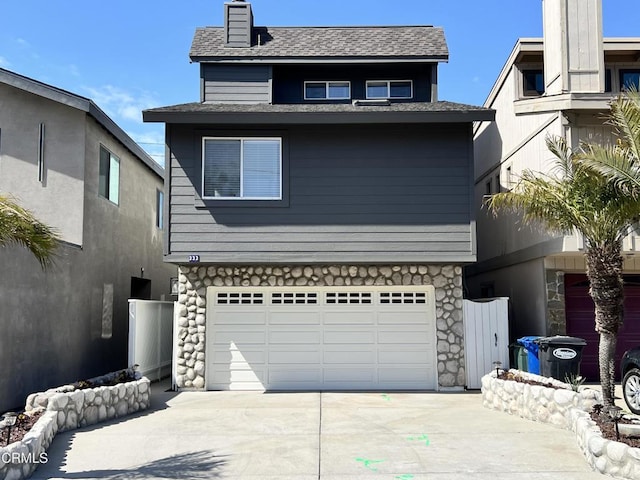 333 Highland Dr, Oxnard, CA 93035 - view of front of house with concrete driveway, an attached garage, a chimney, stone siding, and a shingled roof