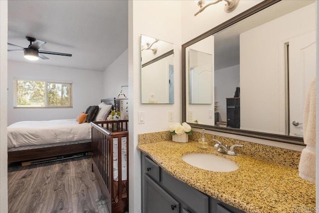 ensuite bathroom with vanity, a ceiling fan, ensuite bath, and wood finished floors
