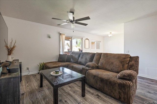 living area with baseboards, a ceiling fan, and wood finished floors