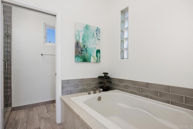 full bathroom featuring baseboards and a bath