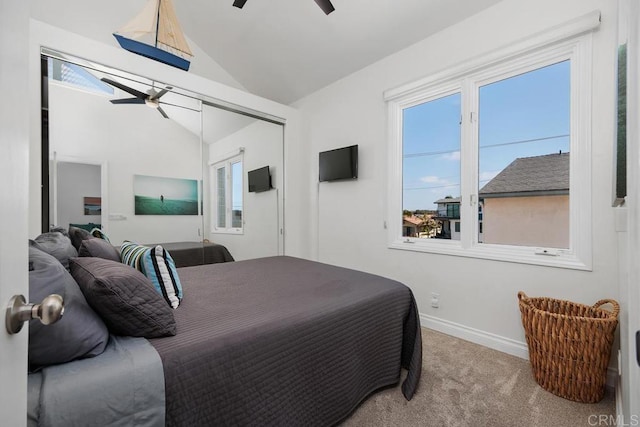 carpeted bedroom with a closet, baseboards, a ceiling fan, and high vaulted ceiling