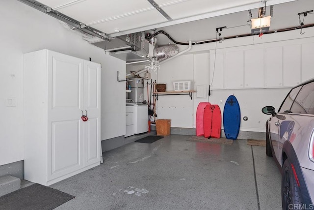 garage featuring water heater and washing machine and clothes dryer