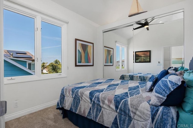 carpeted bedroom featuring baseboards and lofted ceiling