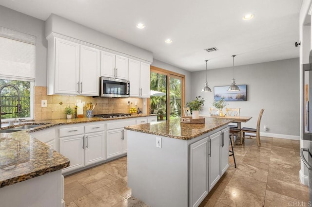 kitchen featuring backsplash, appliances with stainless steel finishes, a sink, recessed lighting, and white cabinetry