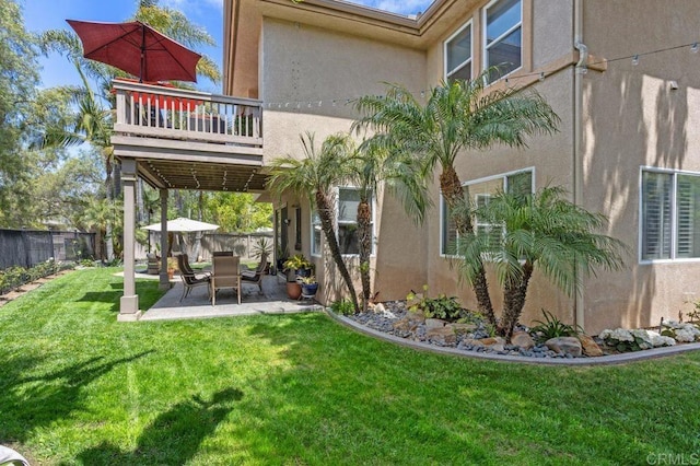 back of property with a patio, a fenced backyard, stucco siding, and a yard