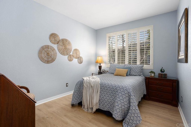 bedroom featuring baseboards and light wood-type flooring