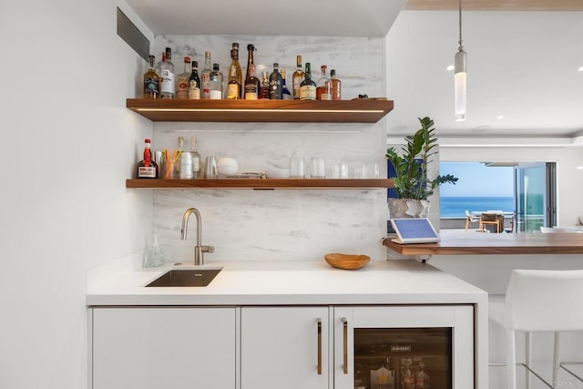 bar featuring beverage cooler, a sink, and wet bar